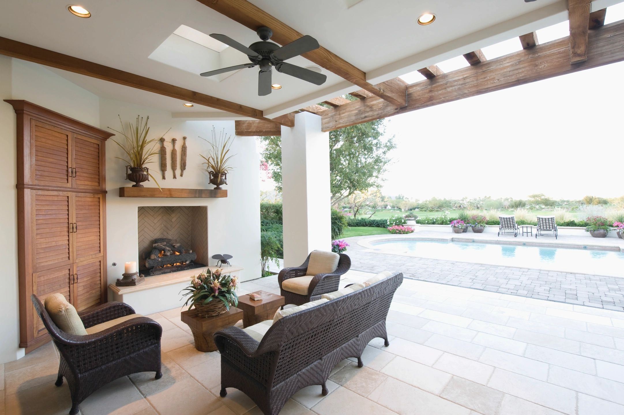 Luxurious covered patio outdoor living fireplace pool