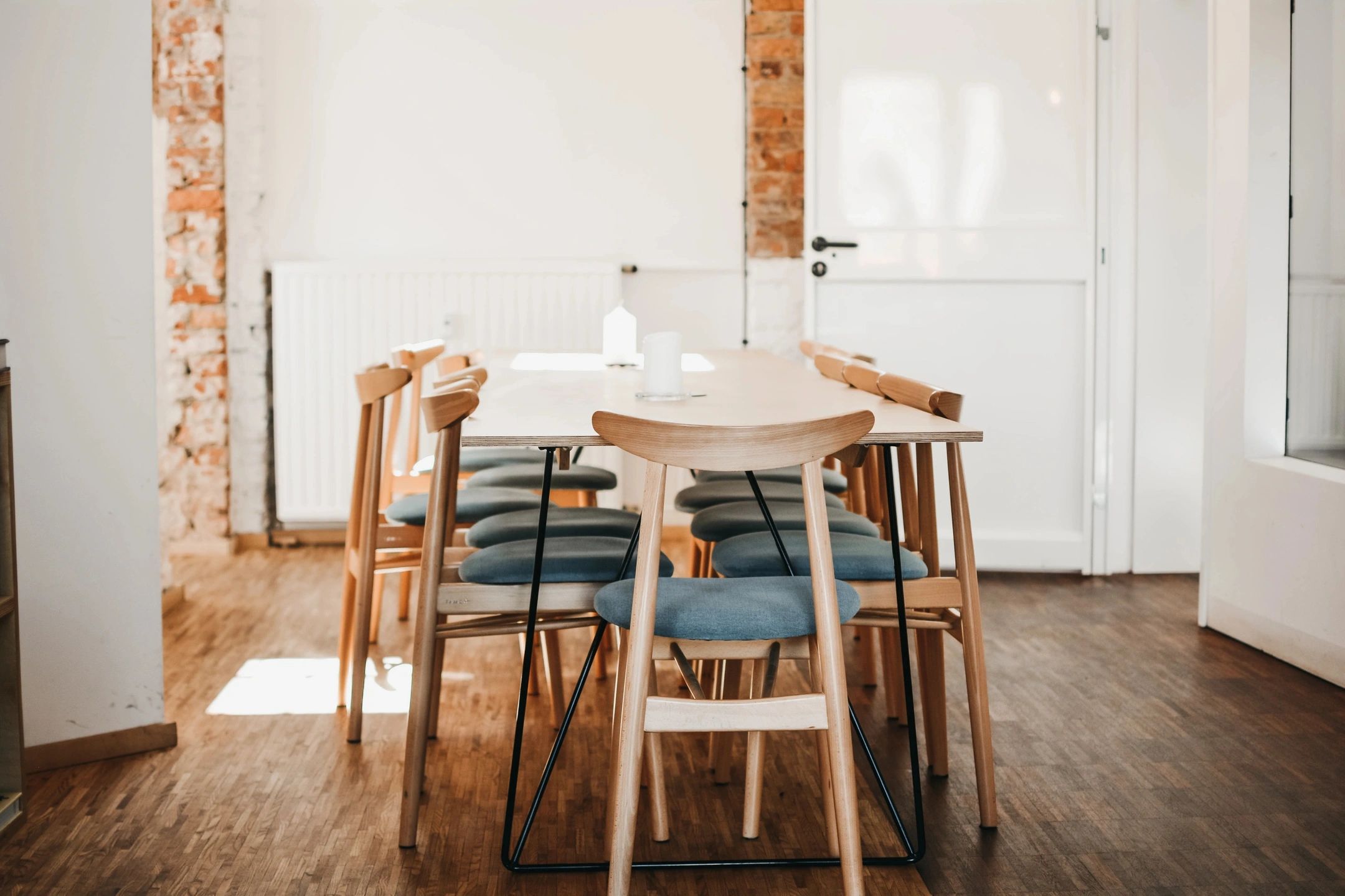 Modern dining space round white table brick columns